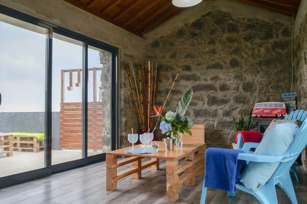 a living room with a wooden table and chairs at BemMEquer - Açores in Nordestinho