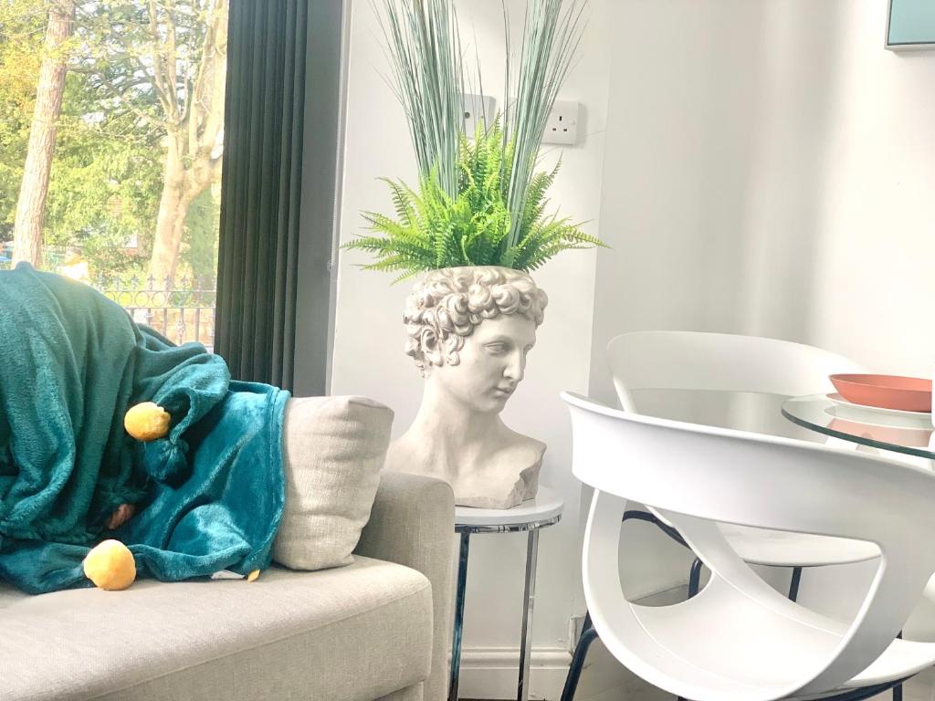 een woonkamer met een stoel en een plant bij Kunda House Moseley Apartments in Birmingham