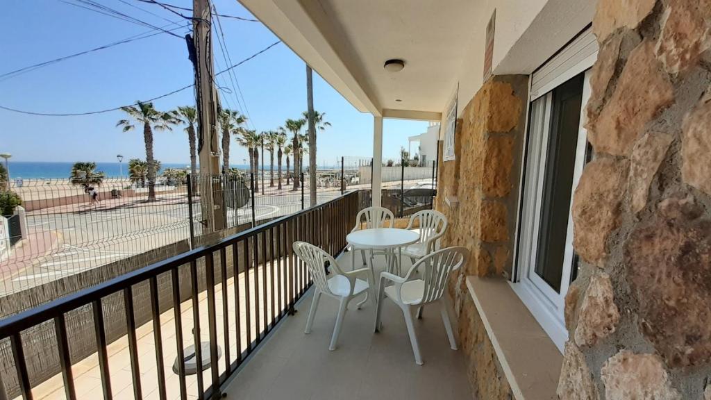 balcón con mesa, sillas y vistas al océano en Apartamentos Dins Mar Apto. 2 en Torredembarra