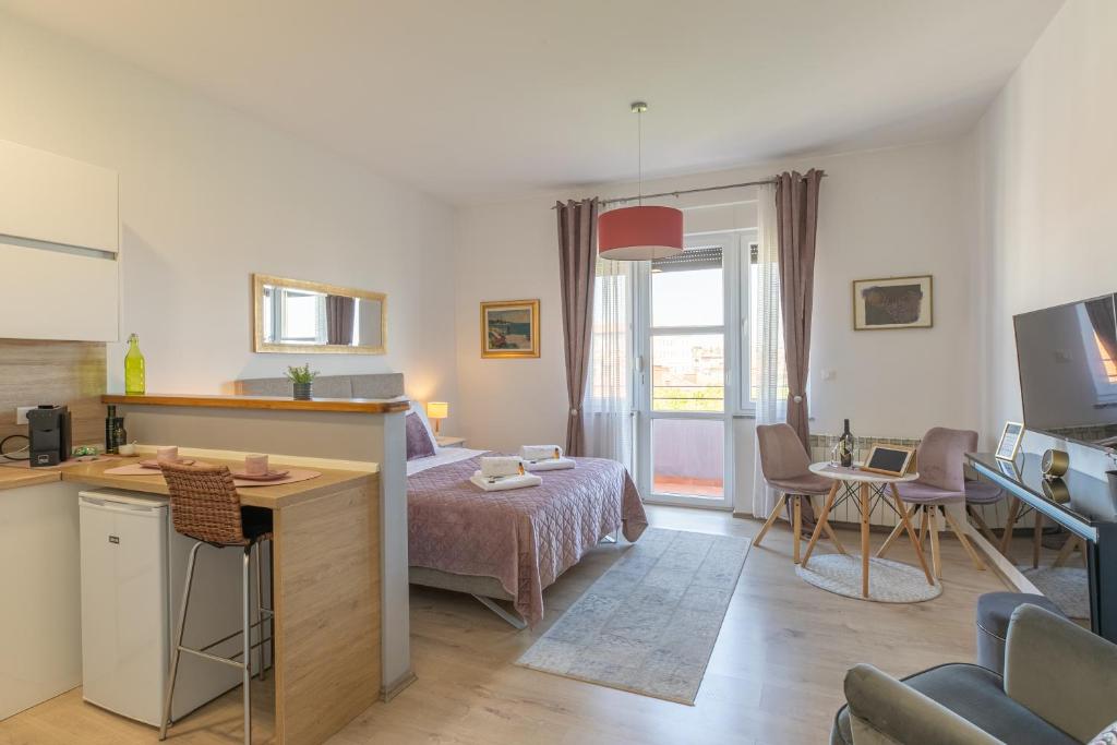 sypialnia z łóżkiem oraz kuchnia z biurkiem w obiekcie Polai Panorama Apartments with FREE Parking w Puli