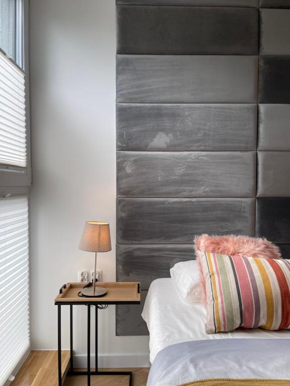 a bed with a wooden headboard and a table with a lamp at Apartament Barlickiego in Bielsko-Biała