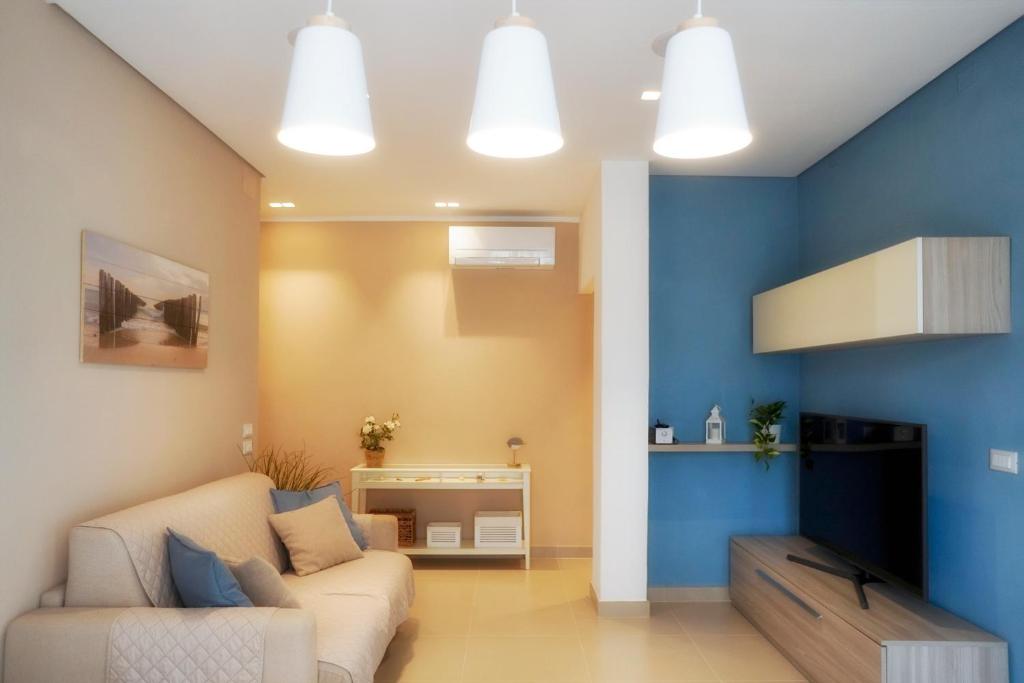 マリーナ・ディ・マッサにあるCasamareMSの青い壁のリビングルーム(ソファ付)