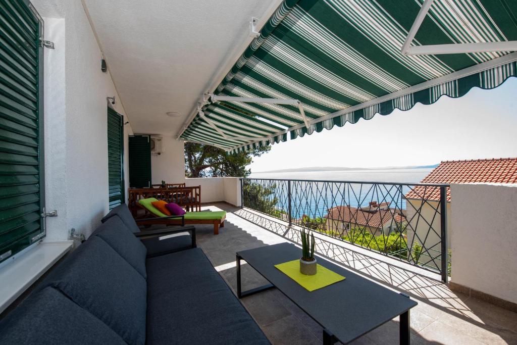 a balcony with a couch and a view of the ocean at Apartment Zora in Trogir