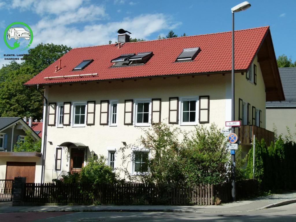 Casa blanca con techo rojo en LakeStarnberg Apartments, en Pöcking