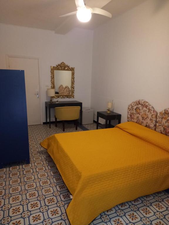 sypialnia z żółtym łóżkiem i biurkiem w obiekcie Curpi de Ma w mieście Bonassola