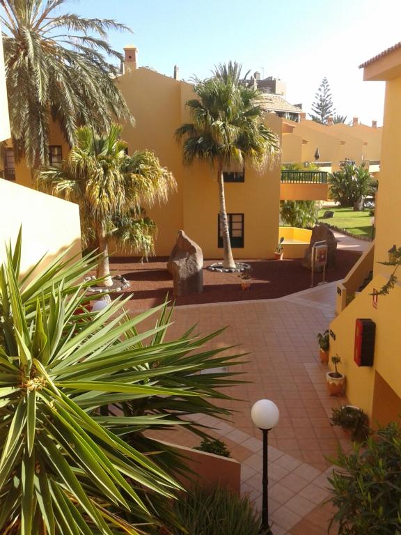 een binnenplaats met palmbomen en een gebouw bij Gepflegte Apartment-Anlage mit Pool und Garten in La Playa Calera