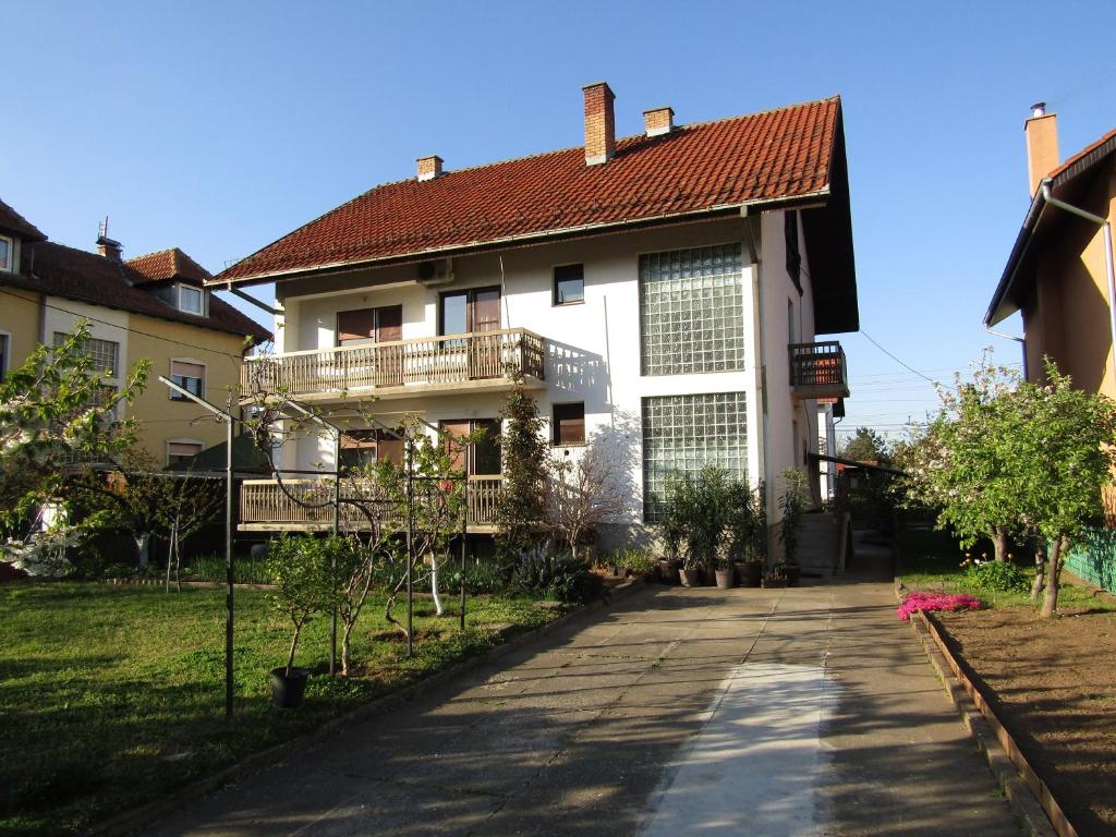 uma grande casa branca com uma varanda e uma entrada em Apartman Milena em Kladovo
