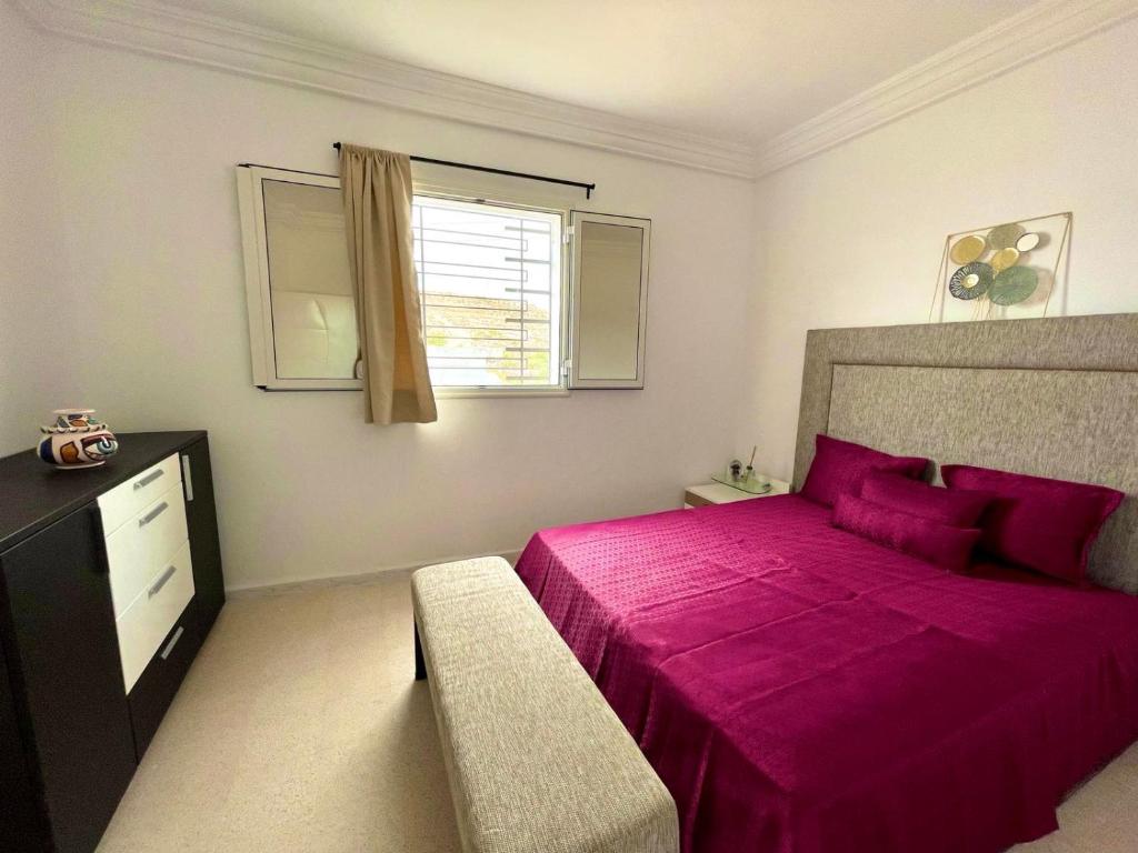 a bedroom with a large pink bed and a window at Soltane Résidence in Hammamet