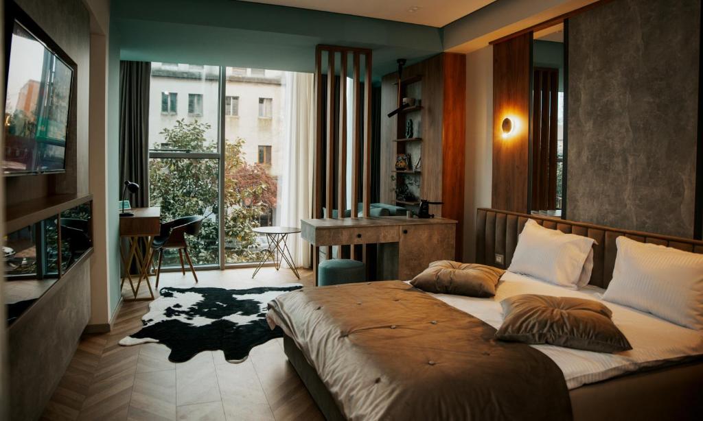 ein Schlafzimmer mit einem großen Bett und einem großen Fenster in der Unterkunft Centropolis Apartments in Shkodra