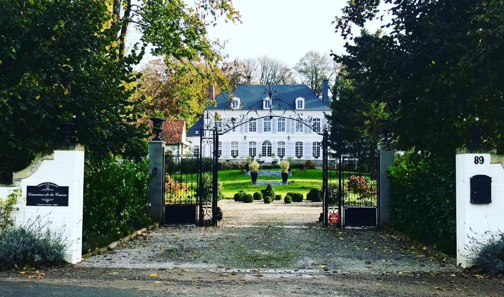 an entrance to a white house with a gate at Domaine de la Course in Doudeauville