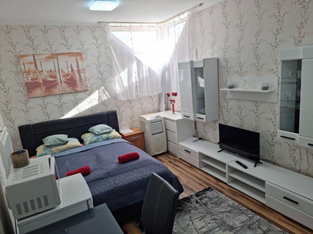 1 dormitorio con 1 cama azul y TV en Csillag Apartman, en Kisvárda