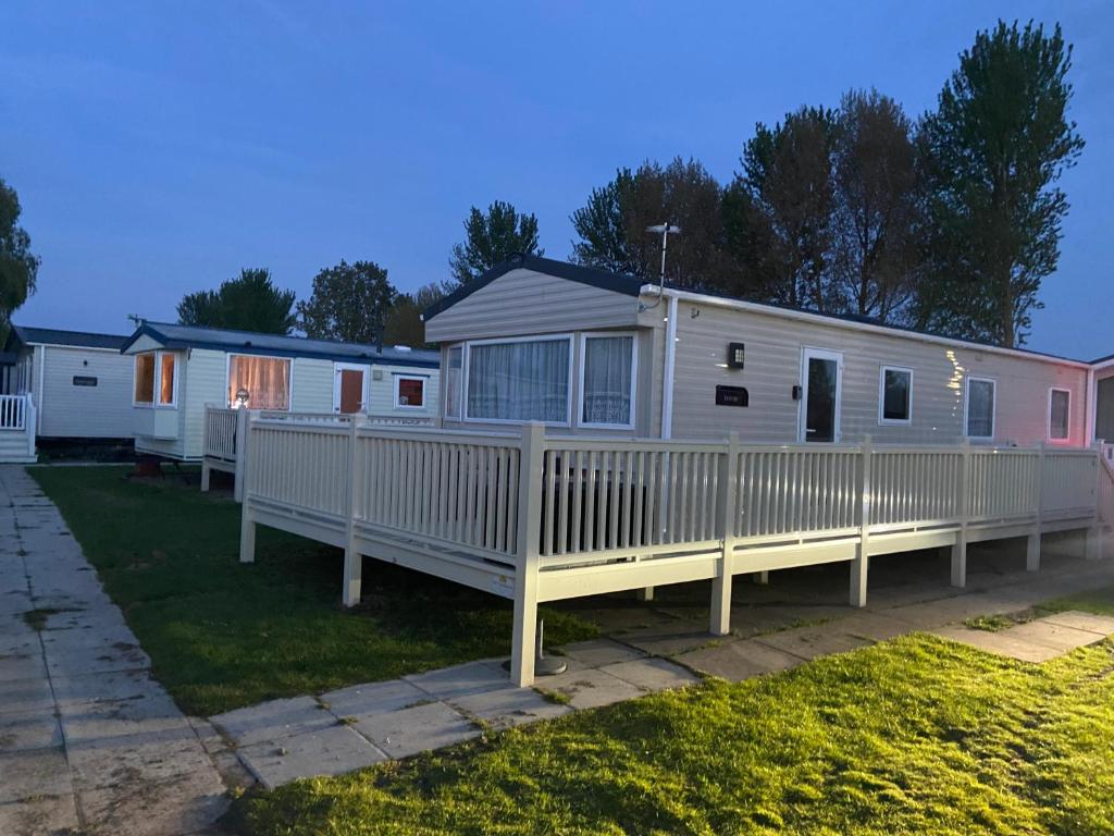 a mobile home with a white fence at The Cedar lake Southview Skegness in Lincolnshire