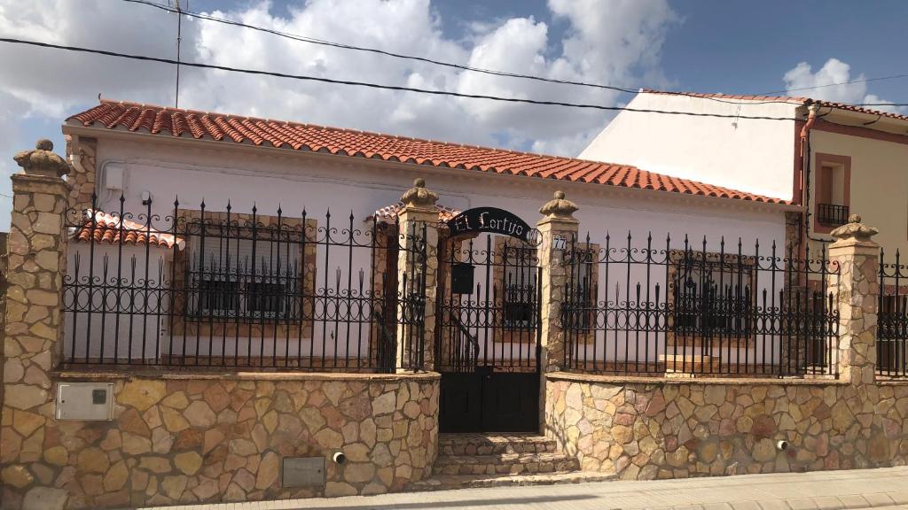 un edificio con una puerta y una pared de piedra en El Cortijo en Villalgordo del Jucar