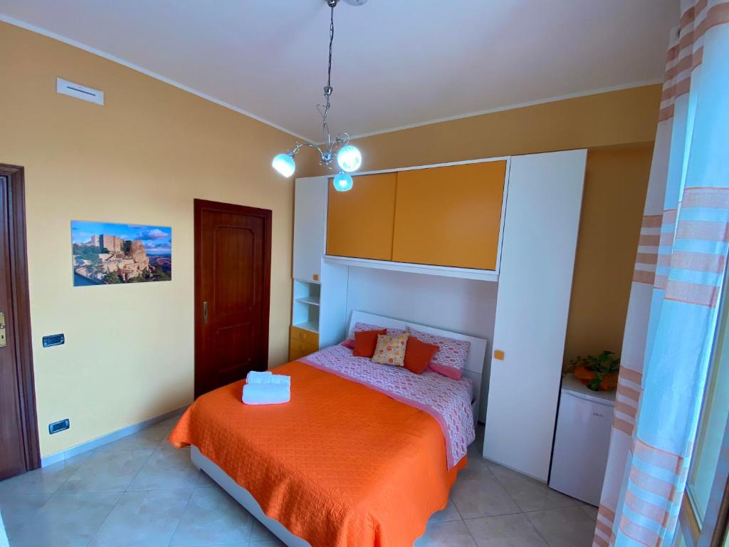 帕切科的住宿－B&B Milena，一间卧室配有一张带橙色毯子的床