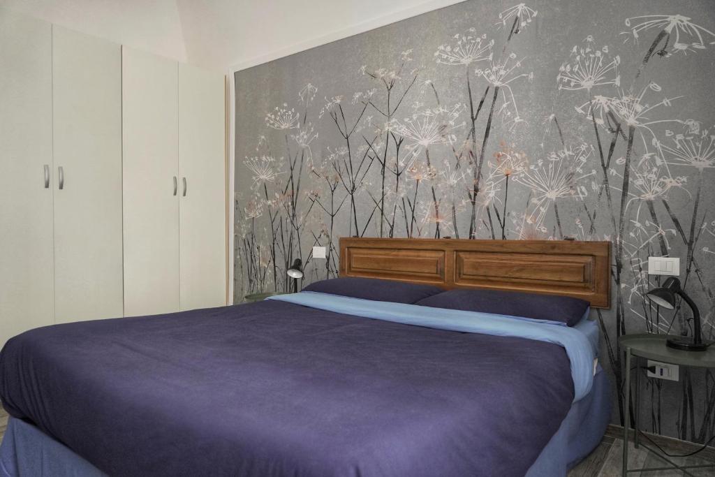 1 dormitorio con cama morada y papel pintado con motivos florales en B&B Interno SG, en LʼAquila