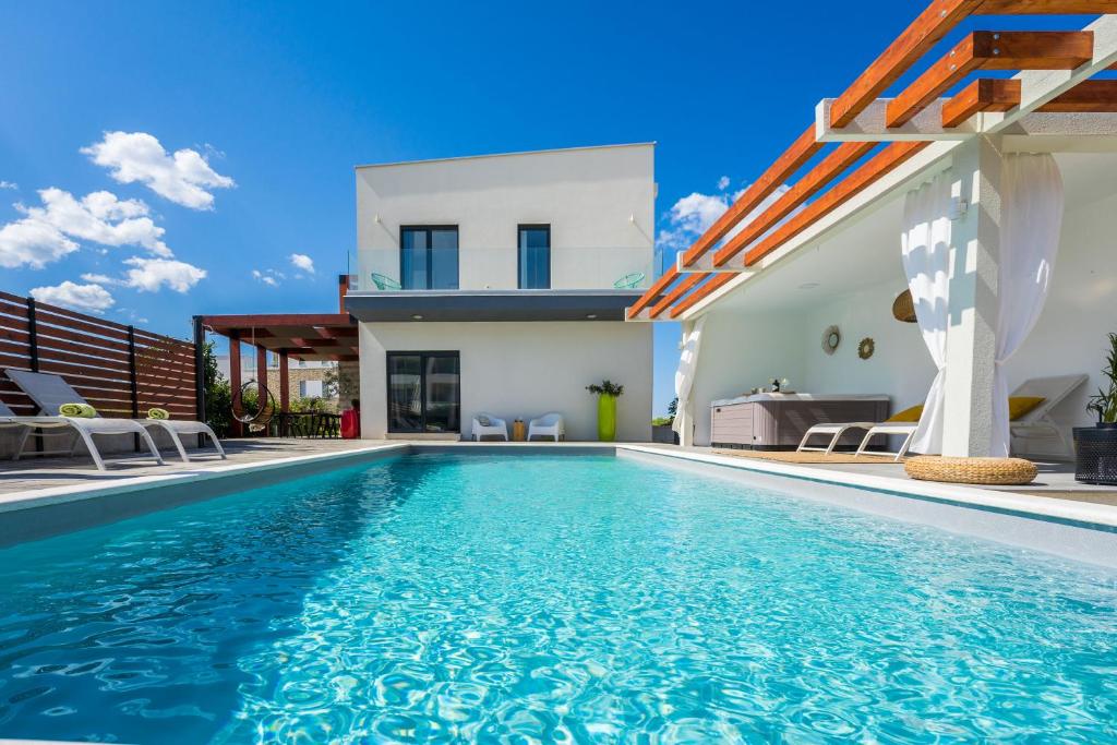 uma villa com uma piscina e uma casa em Villa Olea with heated pool and jacuzzi em Sukošan