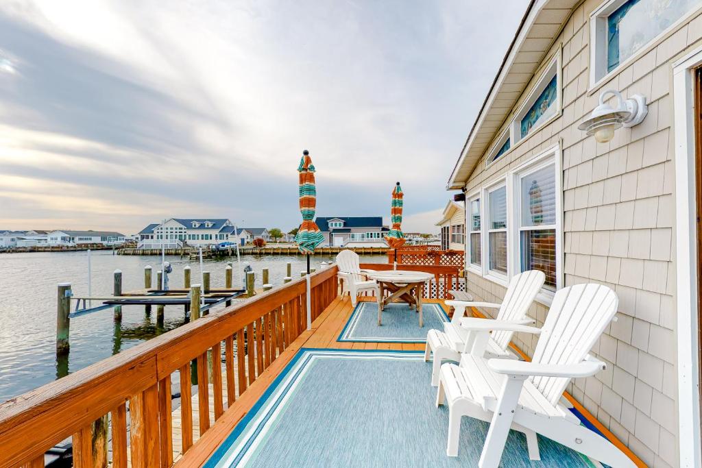 eine Terrasse mit weißen Stühlen, einem Tisch und einem Leuchtturm in der Unterkunft Montego Bay - 197 Pine Tree Road in Ocean City
