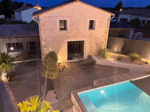 una vista aérea de una casa con piscina en Maison chaleureuse avec piscine et parking, en Saint-Gelais