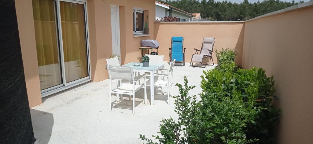 un patio con mesa y sillas. en La Petite Maison du Bassin d'Arcachon - 40 m2, climatisée, indépendante et au calme en Audenge