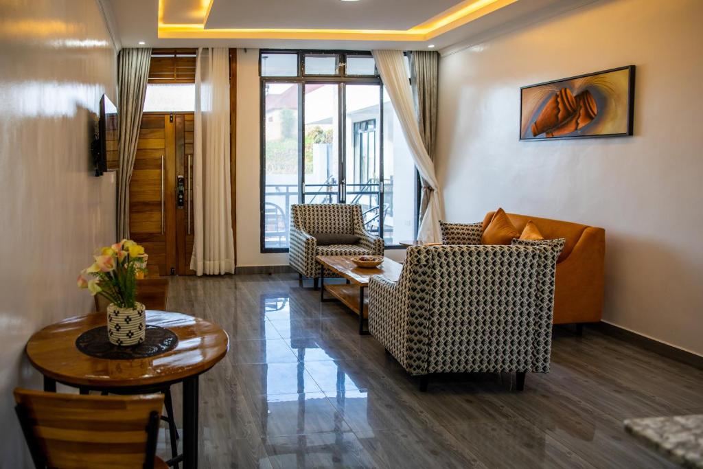 een woonkamer met een bank, stoelen en een tafel bij IKAZE APARTMENTS in Kigali