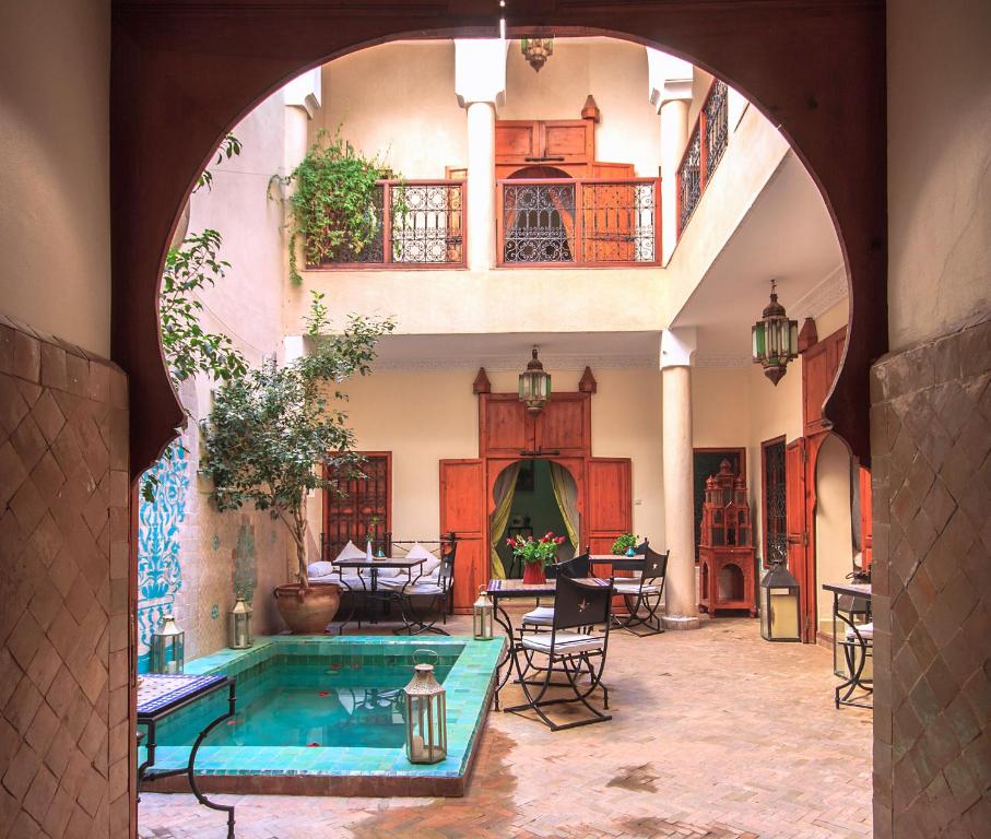 um arco que leva a uma piscina numa casa em Riad Couleurs du Sud em Marraquexe