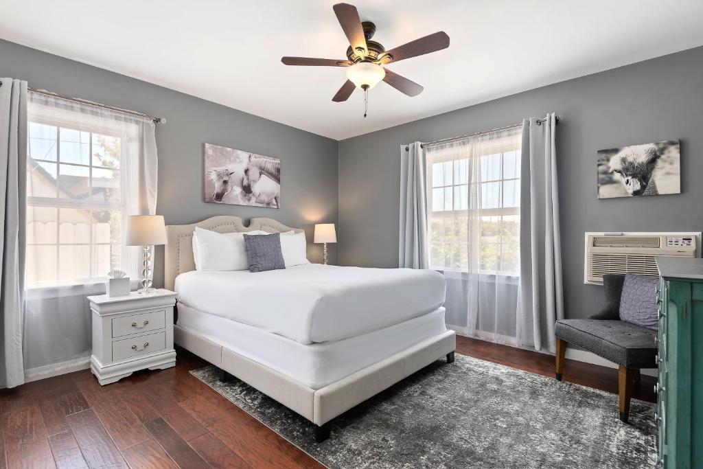 a bedroom with a white bed and a ceiling fan at New Haven Inn in Solvang