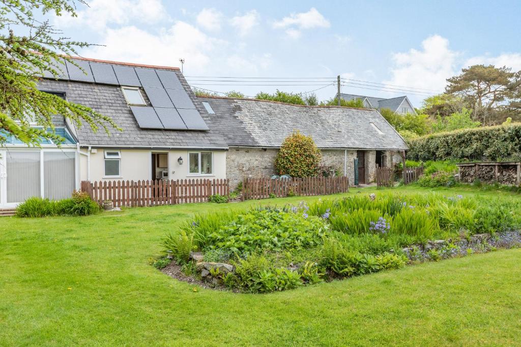 a house with a solar roof and a yard at Stable Cottage in Ilfracombe