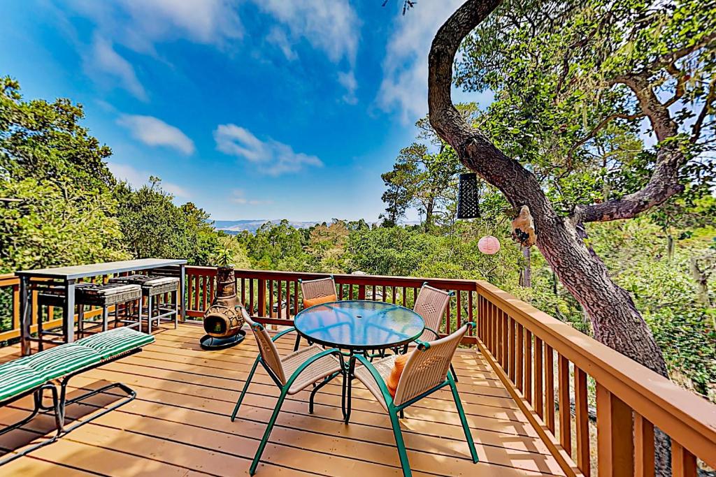 a deck with a table and chairs and a tree at The Silver Lady in Cambria