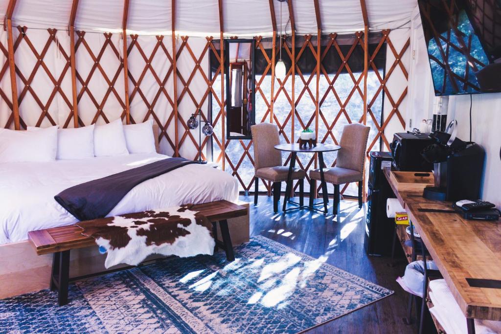 艾斯卡蘭特的住宿－Escalante Yurts - Luxury Lodging，卧室配有一张床和一张桌子及椅子