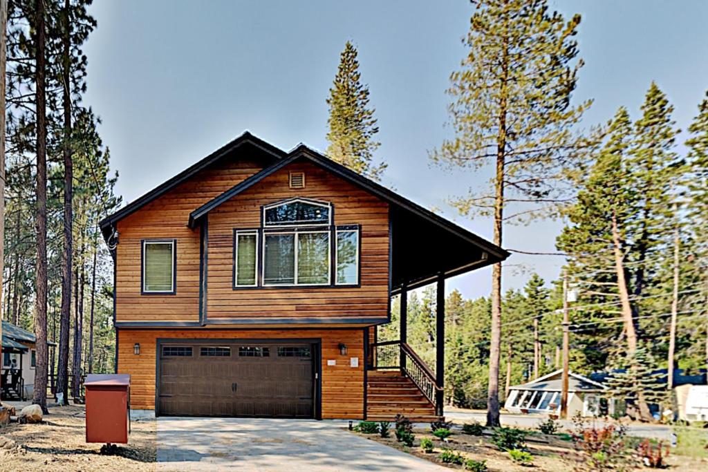 une maison en bois avec un garage dans les bois dans l'établissement Saponi Escape, à South Lake Tahoe