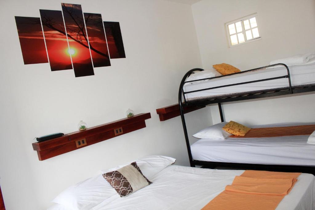 um quarto com 2 beliches e uma fotografia na parede em Hostal San José em Somoto