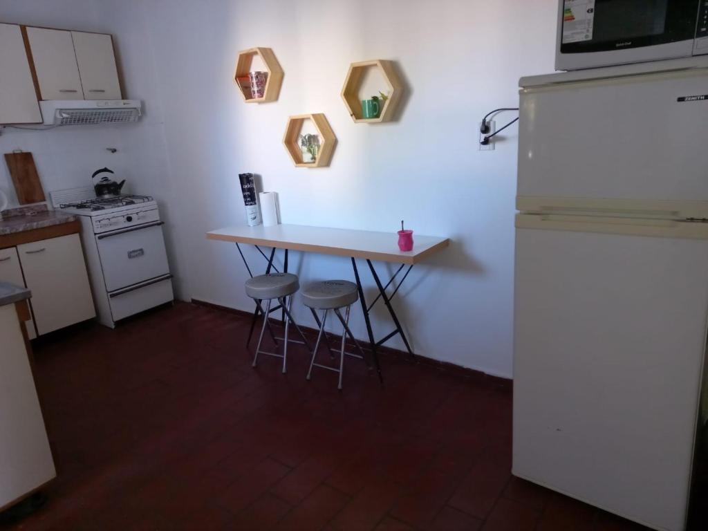 a small kitchen with a table and a refrigerator at Departamento San Lorenzo para 4 personas in Mendoza