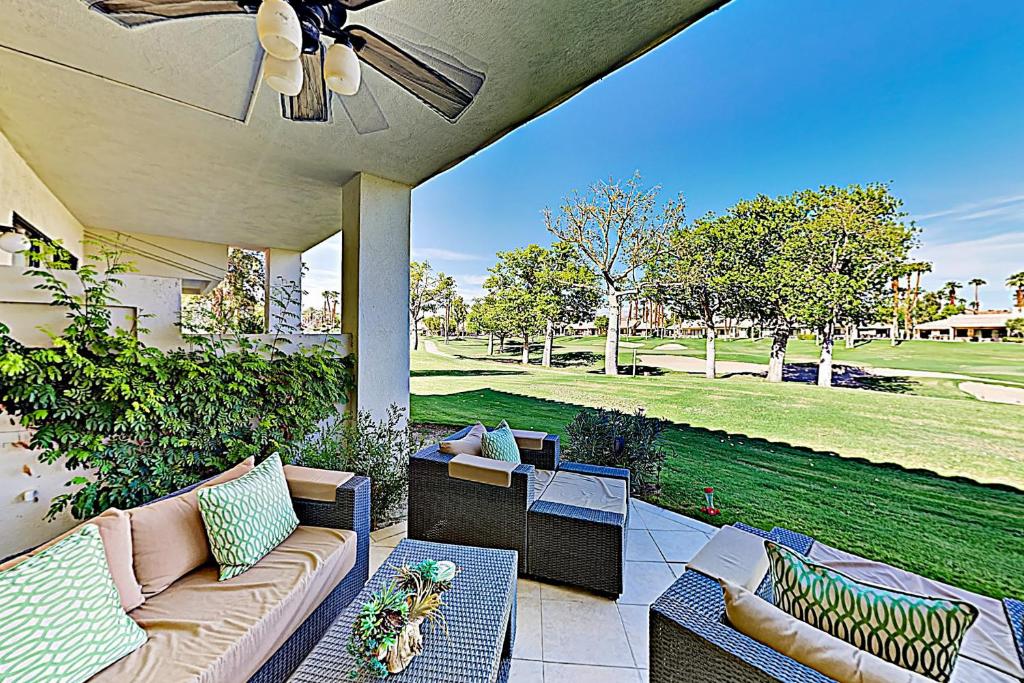 a porch with a couch and chairs on a patio at Riviera Manor Permit# 68147 in La Quinta