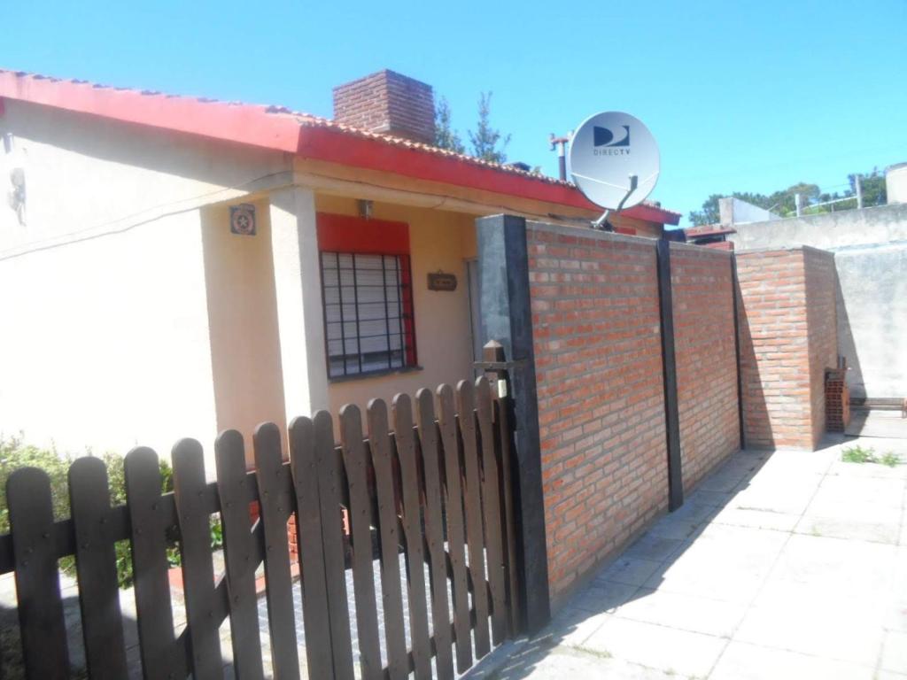 a small house with a fence and a satellite at Nous in San Clemente del Tuyú