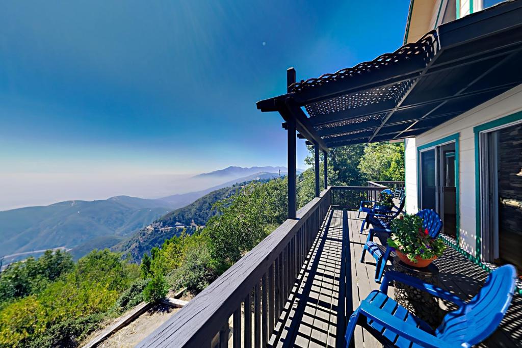 a balcony with blue chairs and a view of mountains at Million Dollar Mountain View in Crestline