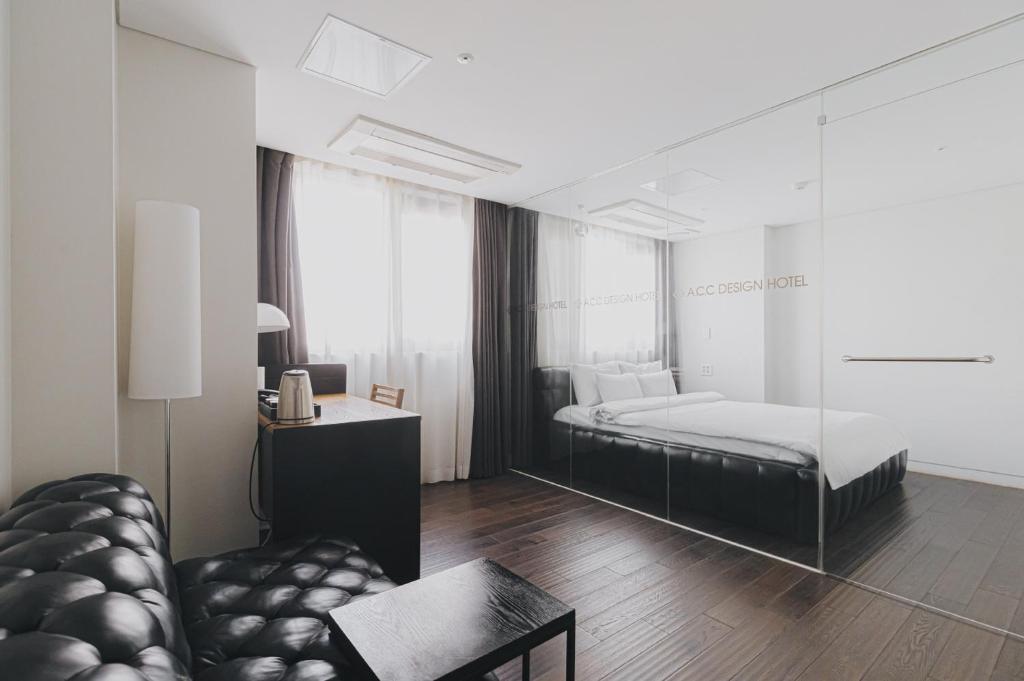 een woonkamer met een bed en een bank bij ACC Design Hotel in Gwangju