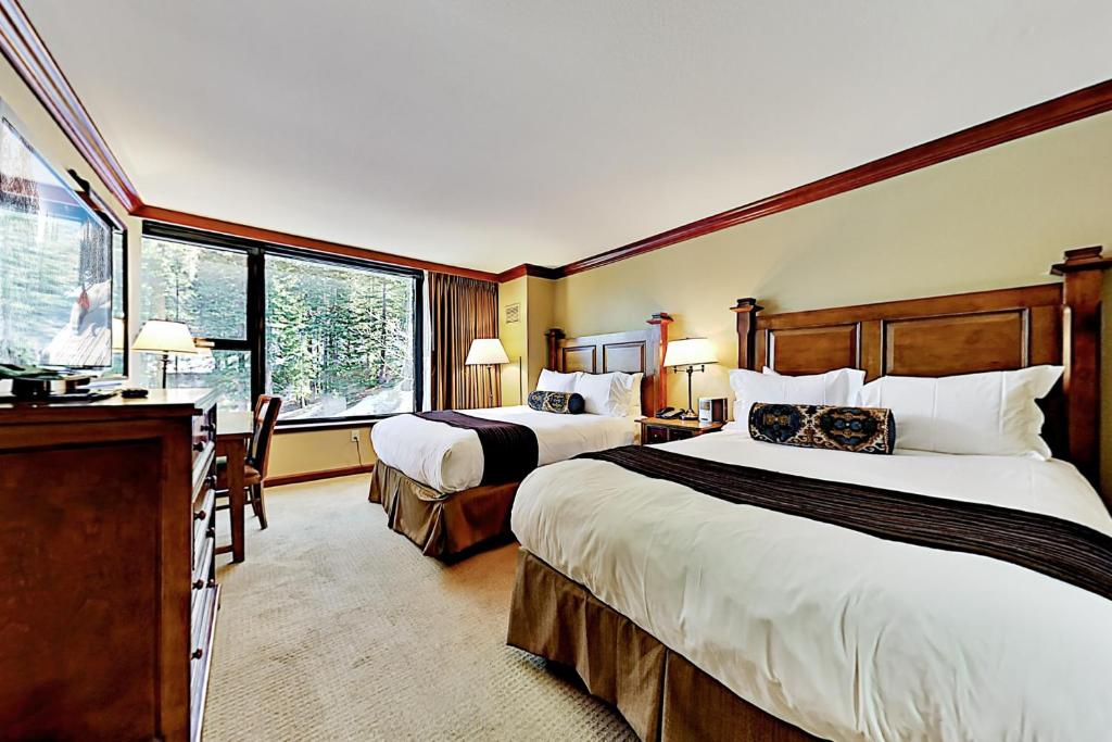 a hotel room with two beds and a desk at Resort at Squaw Creek's 605 in Olympic Valley
