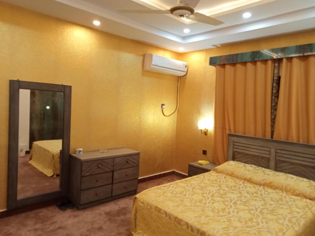 Un pat sau paturi într-o cameră la Shaheen rest house Islamabad