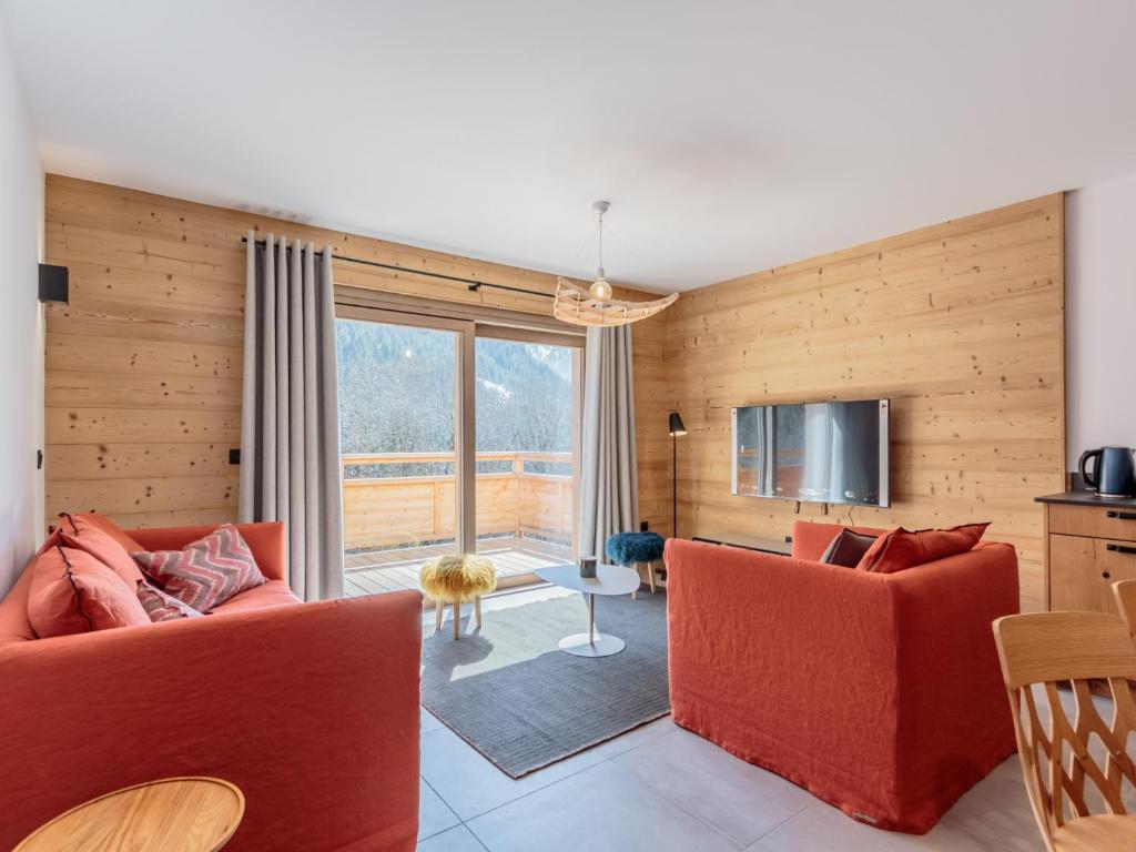 ein Wohnzimmer mit 2 roten Stühlen und einem TV in der Unterkunft Appartement Champagny-en-Vanoise, 4 pièces, 8 personnes - FR-1-638-15 in Champagny-en-Vanoise