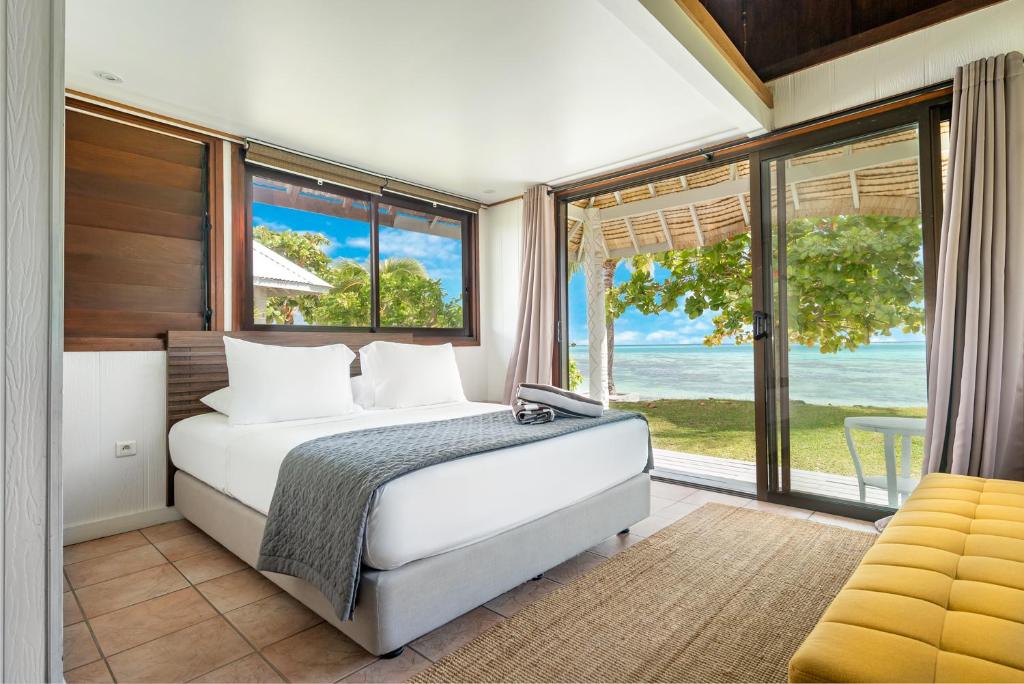 ein Schlafzimmer mit einem Bett und einem großen Fenster in der Unterkunft Moorea Island Beach Hotel in Moorea