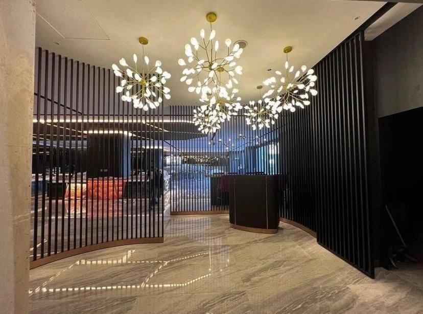 A contemporary lobby entrance with three prominent floral chandeliers.