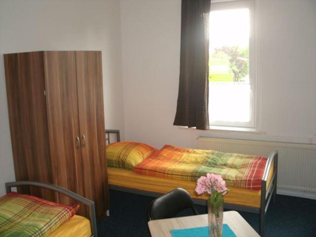 a room with a bed and a table and a window at Gästehaus Harz -Monteurzimmervermietung- in Vienenburg