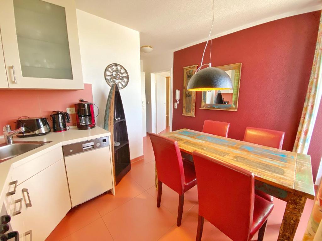een keuken met een houten tafel en rode muren bij Appartements am Rondell Neddesitz, Appartement 310 in Neddesitz