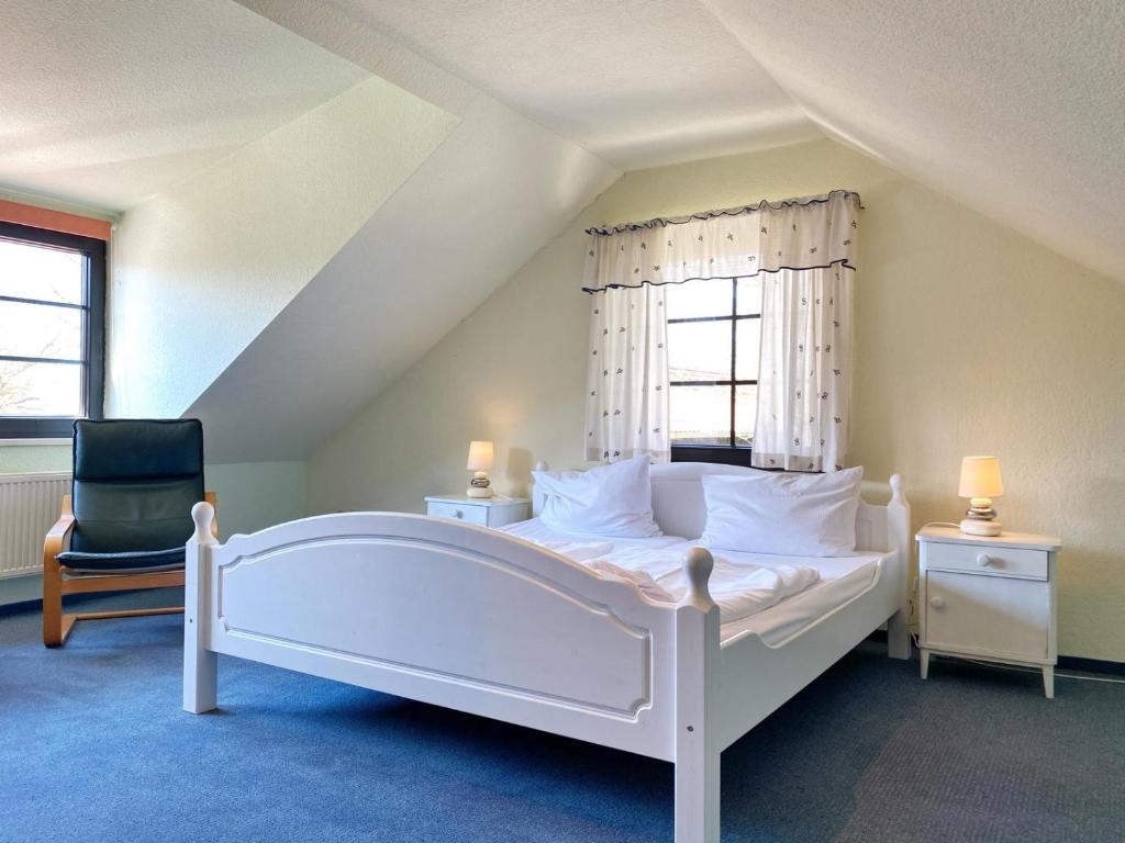 een slaapkamer met een wit bed en een stoel bij Landpension Dubnitz Landpension Dubnitz - Ferienwohnung 12 