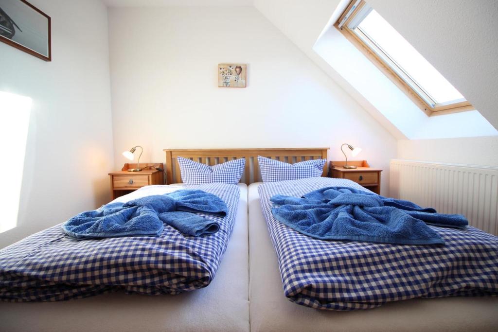 1 Schlafzimmer mit 2 Betten und blauen Decken in der Unterkunft Gutshof Dubnitz Gutshof Dubnitz -Ferienwohnung 8 " Sammy " 