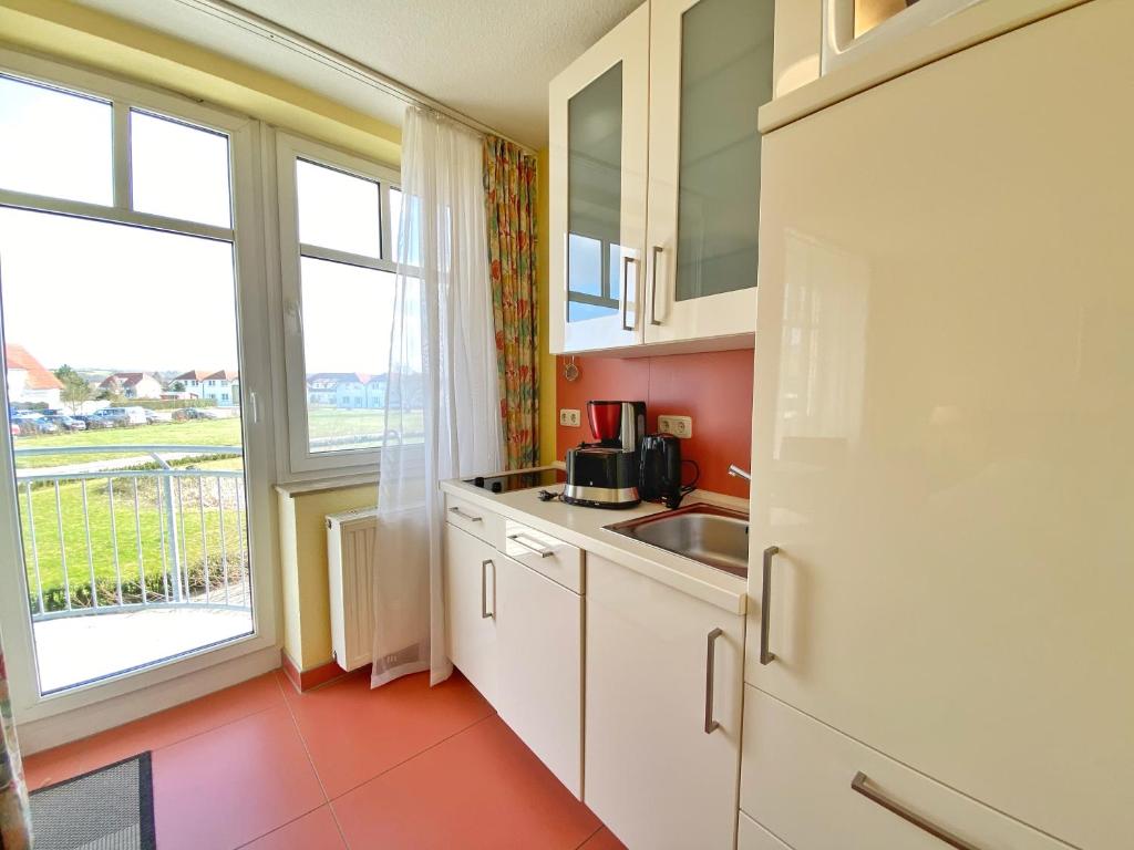 een keuken met een wastafel en een groot raam bij Appartements am Rondell Neddesitz, Appartement 308 in Neddesitz