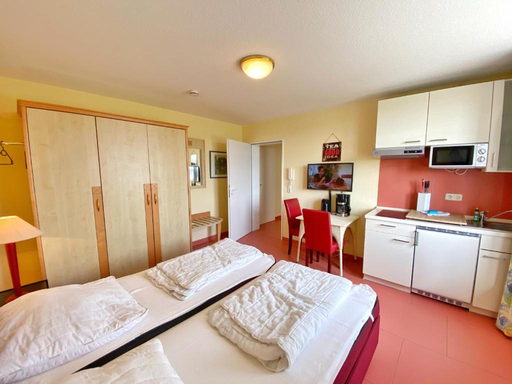 um quarto com 2 camas e uma cozinha com uma mesa em Appartements am Rondell Neddesitz, Appartement 307 em Neddesitz