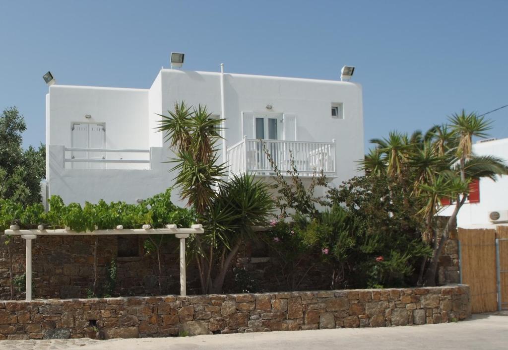 a white house with palm trees in front of it at White Myth in Mýkonos City