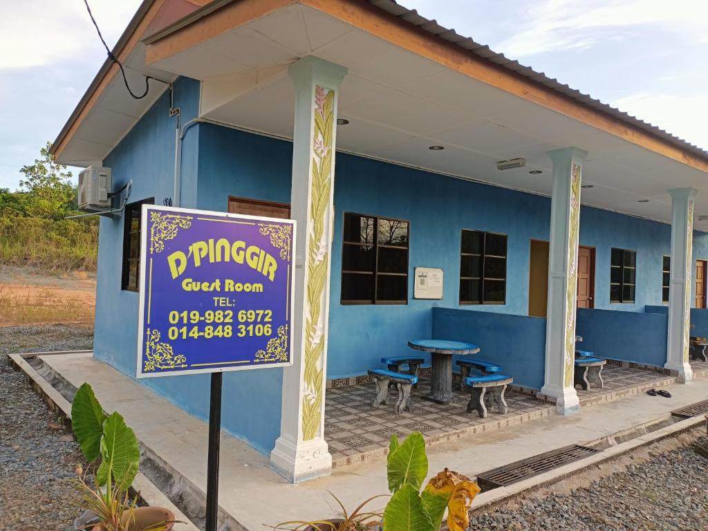 Un edificio azul con un cartel delante. en D&#39;pinggir Guest Room, en Kuala Tahan