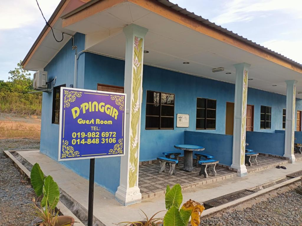 un edificio azul con un cartel delante en D'pinggir Guest Room en Kuala Tahan